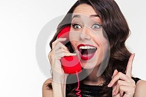 Excited lovely cute woman in retro style talking on telephone