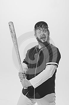 Excited male baseball player wearing retro sports uniform and holding bat isolated on white background. Vintage baseball