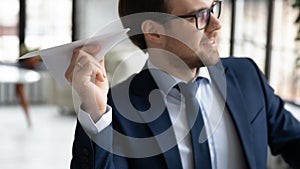 Excited male CEO launch paper plane in office