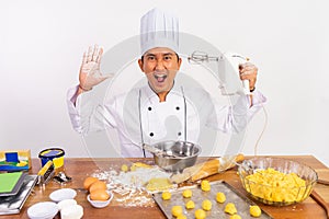 excited male chef holding mixer with camera startling gesture photo