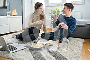 Excited male student pointing fingers up with successful idea and telling it to his girl friend while studying together