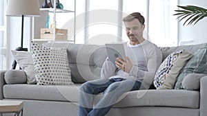 Excited Man Celebrating Success, while Using Tablet Computer