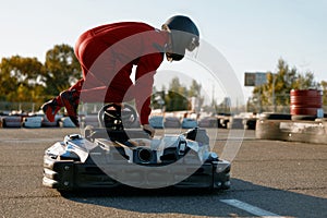 Excited man driver jumping into go-cart getting ready for speed race