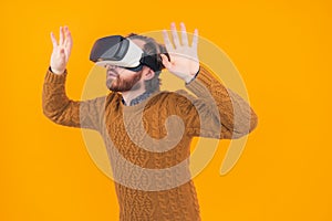 Excited man experiencing virtual reality via VR headset and touching something with his hands