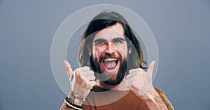 Excited man, face and thumbs up for good job, winning or success isolated against a studio grey background. Portrait of