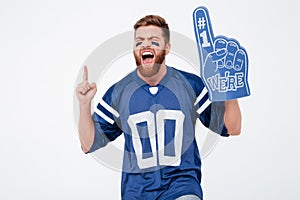 Excited man fan in blue t-shirt standing isolated