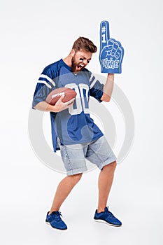 Excited man fan in blue t-shirt standing isolated