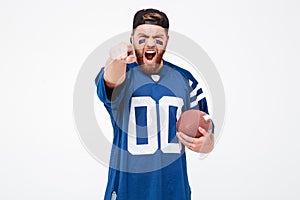 Excited man fan pointing at you holding rugby ball.