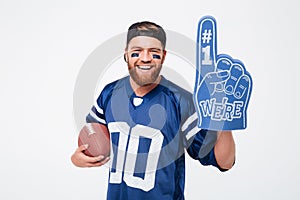 Excited man fan wearing fan glove holding rugby ball.