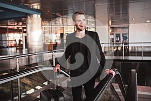 Excited man going through the airport with his luggage photo