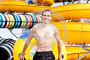 Excited man having fun on water slide in aqua park