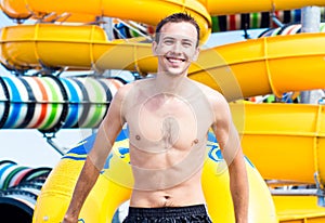 Excited man having fun on water slide in aqua park