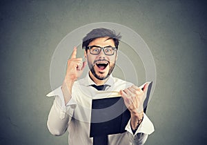 Excited man having idea while reading a book