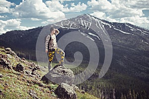 Excited man hiking on a mountain top with backpack enjoy the view and looking for adventures.