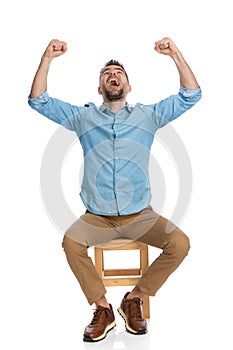 Excited man in his forties with arms above head celebrating victory