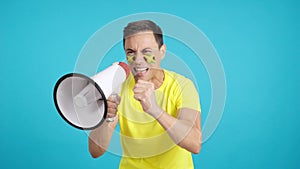 Excited man with jamaican flag on face using a megaphone