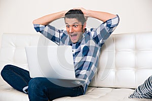 Excited man looking game on laptop