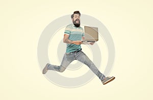 Excited man midair isolated on white. Bearded man jumping with laptop. Energetic man computing
