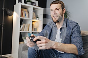 Excited man playing video games with joystick