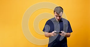 Excited man playing video games on mobile phone