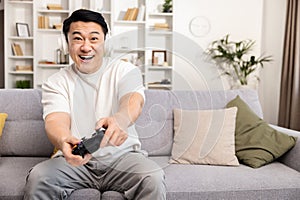 Excited Man Playing Video Games with Wireless Controller