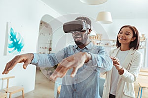 Excited man playing with VR headset in coffeehouse