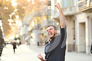 Excited man raising arms celebrating sucess