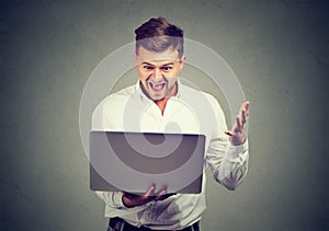 Excited man reading great news on his laptop