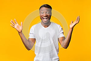 Excited Man Screaming In Delight Standing Over Yellow Background