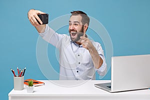 Excited man in shirt work at desk with pc laptop isolated on pastel blue background. Achievement business career concept