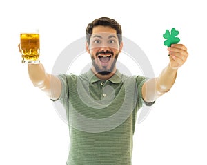 Excited man showing a bier mug and a four leaf clover.