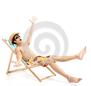 Excited man sitting in lounger chair