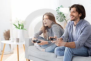 Excited man and woman playing video games at home