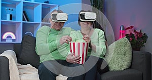 Excited Mature Senior Couple is Having Fun Using VR Glasses in Living Room Watching the Movie at Home. Elderly Couple