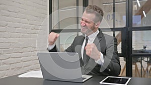 Excited Middle Aged Businessman Celebrating Success on Laptop