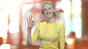 Excited middle-aged woman showing OK sign.