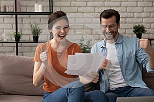 Excited millennial couple get pleasant news in paper letter