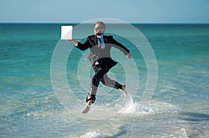 Excited millennial hispanic business man in suit on sea. Summer vacation, business on sea beach. 40s business man on