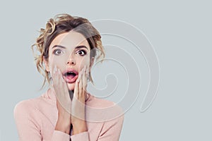 Excited model woman with mouth open, portrait. Surprised girl on background with copy space