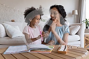 Excited mom and cheerful kid girl clapping high five hands