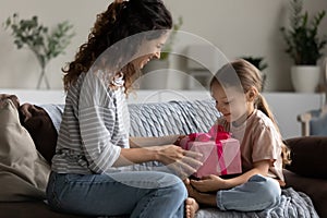 Excited mommy giving gift to happy little daughter girl