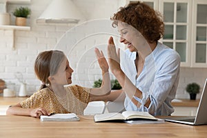 Excited mother give high five to small daughter praise child