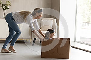 Excited mother with little daughter playing pirates at home together