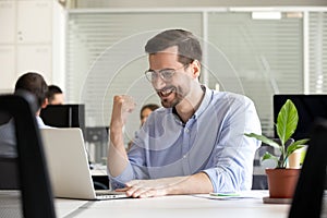 Excited motivated worker happy by receiving good news in email