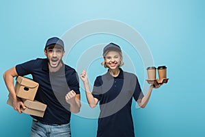 excited multicultural couriers showing win gesture