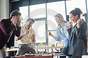 Excited multiethnic business people playing table