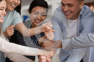 Excited multiracial people engaged in teambuilding activity at meeting photo