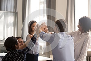 Excited diverse colleagues give high five during office meeting