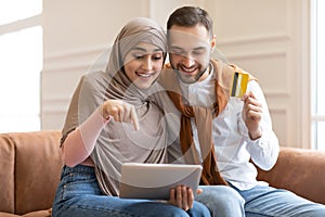 Excited Muslim Couple Shopping Online With Digital Tablet At Home