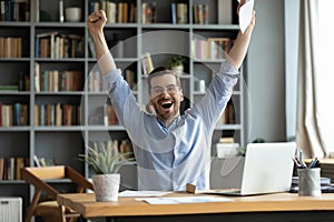 Excited overjoyed man received good news in letter, celebrate success photo